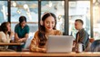 © ochikosan - 賑わっているカフェでノートパソコンを使ってリモート会議をしているアジア人女性（Asian woman having a remote meeting on a laptop in a busy cafe）