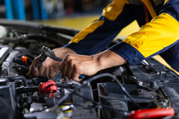 Close up mechanical hand with tools and spanner. Hispanic latin male mechanic repairs car in garage. Car maintenance and auto service garage concept