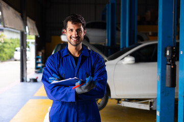 Portrait hispanic latin male mechanic repairs car in garage. Auto car mechanic professional working and checking car engine at garage. Car repair and maintenance