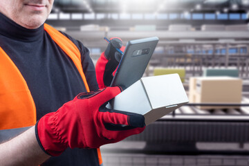 Poster - Man employee distribution center. Conveyor with parcels behind worker. Distribution center with automated conveyor. Cropped specialist holds box and gadget. Fulfillment of goods. Logistics, storage