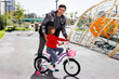© Studio Peace - Father teaching his daughter how to drive a bicycle.