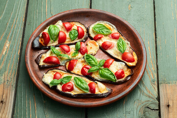 Poster - Italian mini pizza . Aubergine (eggplant ) with mozzarella cheese and basil . On rustic background