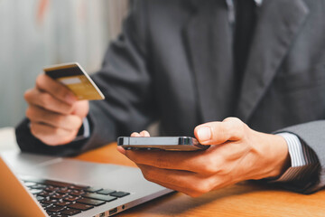 Close up Male hands holding credit card and smartphone, man paying online, credit card shopping, using banking service, entering information, shopping, ordering in internet store, doing secure payment