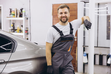 Wall Mural - Confident Auto Mechanic Standing Beside Car in Garage Workshop with Tools