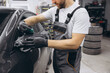© anatoliycherkas - Close-Up of a Professional Applying Protective Film on a Car Mirror in an Auto Workshop