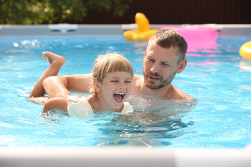 Poster - Happy daughter and her father having fun in swimming pool