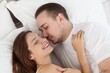© New Africa - Cute couple lying on bed at home