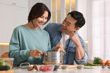 Wall Mural - Happy lovely couple cooking together in kitchen