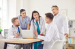 © Studio Romantic - Group of professional doctors sitting with laptop at the desk on meeting discussing diagnosis, checking test results or planning treatment in clinic. Medical staff, healthcare and teamwork concept.