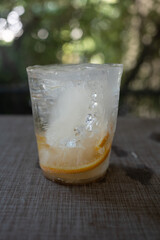 Frozen ice with slice orange fruit inside cup shape from the freezer refrigerator against nature background