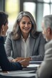 © Art_You - Confident businesswoman in professional attire smiles while engaging in a conversation during a business meeting