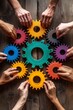 © Sebastian - Diverse hands collaborating to assemble colorful gears on a wooden table.