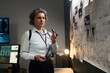 © pressmaster - Woman Reviewing Crime Scene Photos and Analyzing Clues on Evidence Board while Holding Flashlight in Office Setting