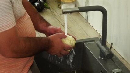 Wall Mural - Man is washing cauliflower