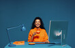 © Jacob Lund - Employee enjoying a coffee break while working at her computer, color blocking studio shot
