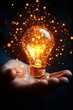 © Sebastian - A glowing light bulb in a hand, radiating sparks and warmth in a dark setting.