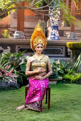 a beautiful young girl wearing traditional Balinese clothing called payas Agung, elegant and graceful with dominant gold decorations