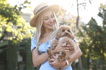 Wall Mural - Beautiful young woman with cute dog in park