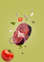 Flying raw beef ossobuco steak-levitation concept-green background