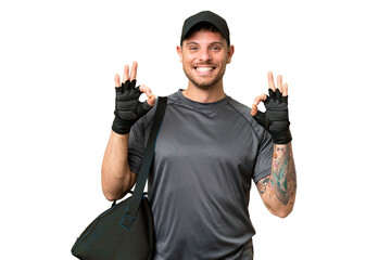 Young sport man with sport bag over isolated chroma key background showing an ok sign with fingers