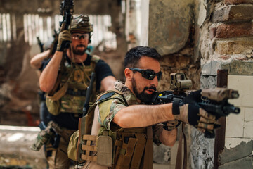 Group of soldiers with weapon in a mission in ruined building.