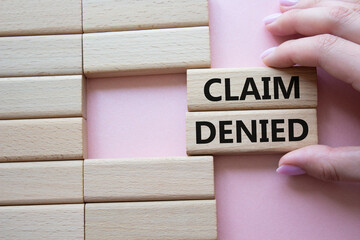 Claim denied symbol. Wooden blocks with words Claim denied. Businessman hand. Beautiful pink background. Business and Claim denied concept. Copy space.