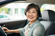 © luismolinero - Middle aged Chinese woman inside a car and driving