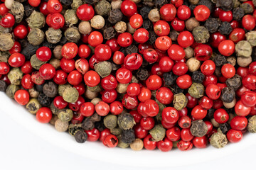 A mixture of different peppercorns on a white background