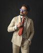 © Viorel Sima - relaxed young man in beige suit fixing his red tie