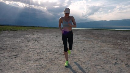 Poster - Young sports woman running on lake shore on summer day