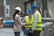 © 24K-Production - Female manager talking with two workers on the factory line, including one with a disability, about the production process.