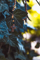 Wooden rosary with cross - with bokeh in background