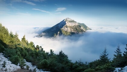 Wall Mural - A serene mountain peak emerging from misty clouds, with distant tree lines fading into an un.