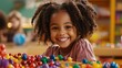 © BOJOShop - Happy African American Girl Playing with Colorful Toys in Kindergarten