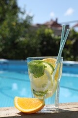 Canvas Print - Tasty cocktail in glass near swimming pool outdoors