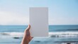 © Lin_Studio - Hand holding blank paper at beach