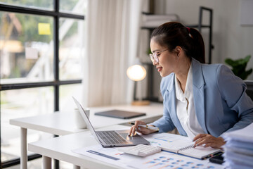 Wall Mural - Asian accountant woman working with calculator and laptop at office