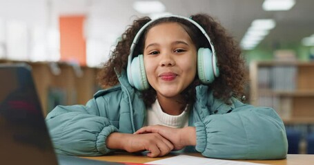 Poster - Face, girl or child in headphones for online class, remote education or elearning in library with smile. Virtual school, portrait or happy student listening on headset technology on teaching platform
