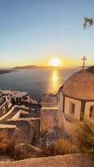 Wall Mural - Beautiful sunset in Santorini island, Greece. Old church with sea view. Summer travel and vacation. Vertical video
