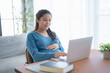 © Charlie's - Pregnant asian woman using laptop at home pregnant businesswoman typing on laptop working on remote project in home office pregnancy concept
