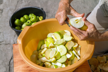 Cutting natural apples. Hands of an elderly woman. Canning fruits from the garden.