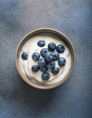 Poster - bowl of yogurt topped with blueberries with empty space for text top view 