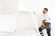 © Angelov - worker with screwdriver assembles and installs furniture in the children's room