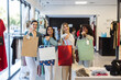 © Westend61 - Smiling multiracial friends holding shopping bags at fashion store