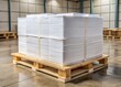 © Curie - A wooden pallet holds a compact bundle of white copy paper reams, shrink-wrapped together with a uniform precision.