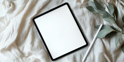 White tablet, pen, eucalyptus leaves, white fabric.