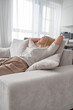 © Николай Амосеев - A woman relaxing on a sofa in a modern living room, enjoying a moment of calm and contentment