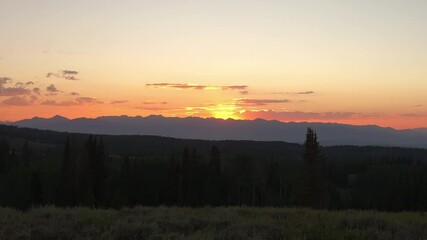 Wall Mural - Golden Horizon Over Silhouetted Mountainscape Near Countryside During Sunset. Timelapse