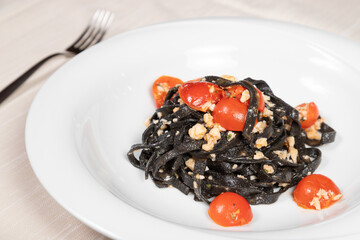 Cuttlefish ink fettuccine with shrimp and calamari.
Gourmet dish of cuttlefish ink tagliatelle with fish