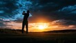 © musa - A golfer silhouetted against a dramatic sunset sky, swinging a club on a golf course.